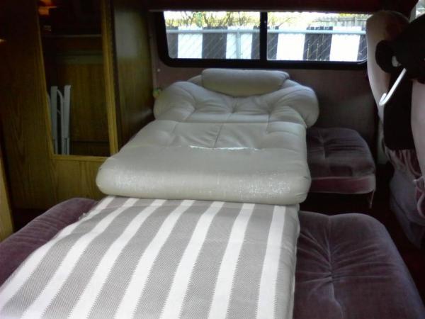 Single Bed Setup in my 1989 Dodge Xtra Class B.  Folded the two back seats down, cut a board to specks to place between the seats then put these cushions in.