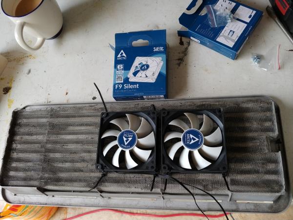 Two cooling fans mounted to the upper vent grille. Electric connection is via a disconnect plug.  Be sure to leave insect screening intact.